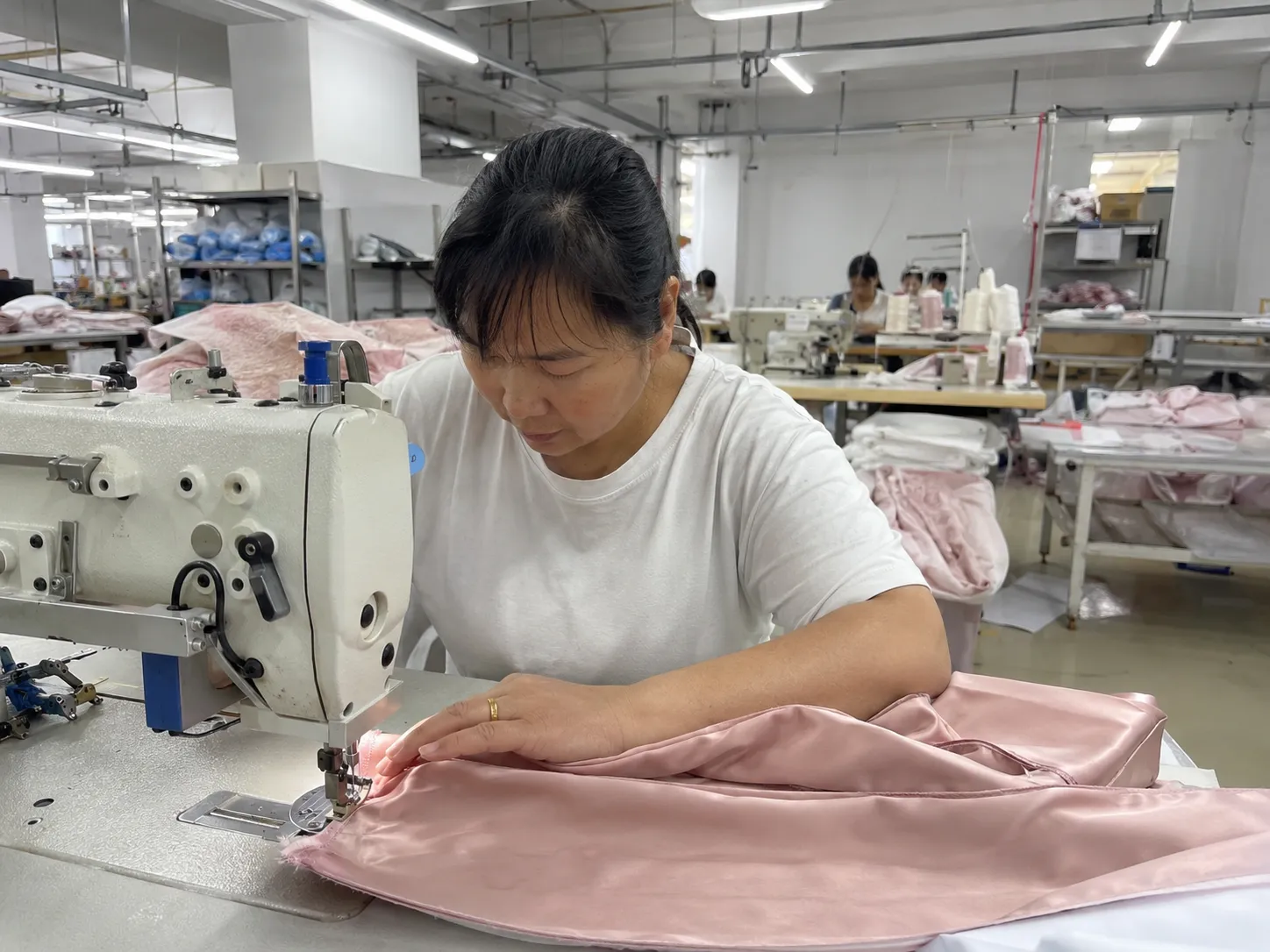 In-process check during sewing of silk products, inspecting seams to support consistent quality for B2B private label silk orders