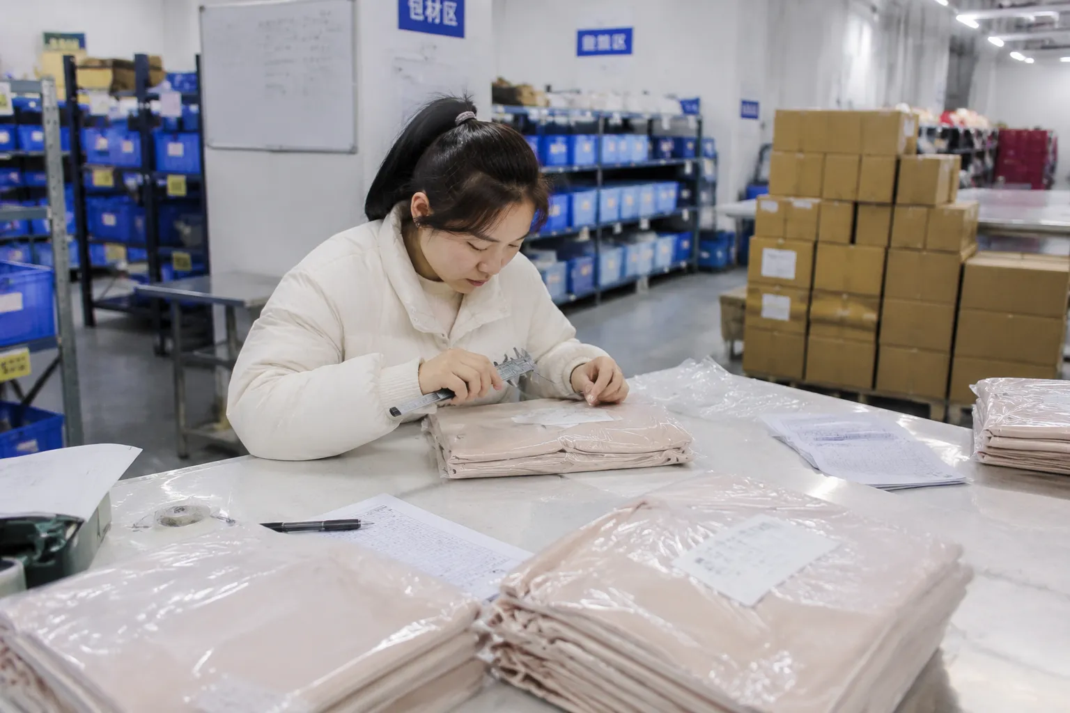 Final inspection before packing at a private label silk manufacturer, measuring silk product edges with calipers to support consistent quality for B2B