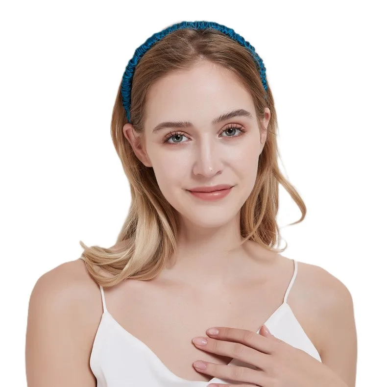 Model wearing a teal custom silk headband for private label beauty and hair accessory brand collections