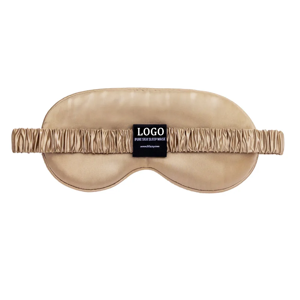 Back view of champagne contoured silk sleep mask with gathered elastic strap and custom logo label for private label beauty and travel brands