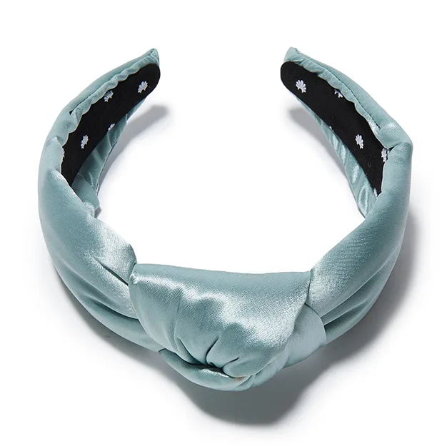 Detail view of aqua knotted custom silk headband with inner floral lining for private label gift set branding