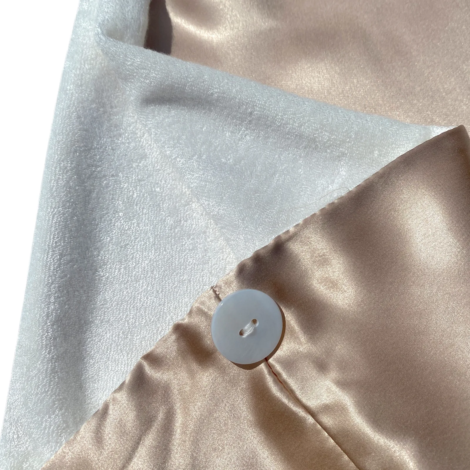 Custom silk hair towel wrap detail with button closure, champagne outer finish, and soft inner lining for private label hair care sets