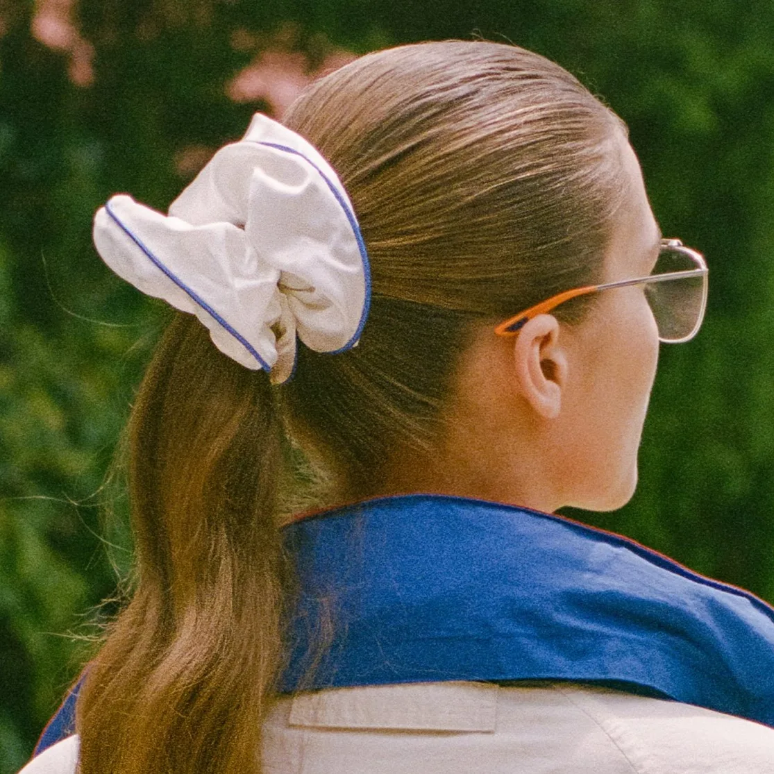 Ivory custom silk scrunchie with blue trim shown in a ponytail for private label hair accessory brand lifestyle review