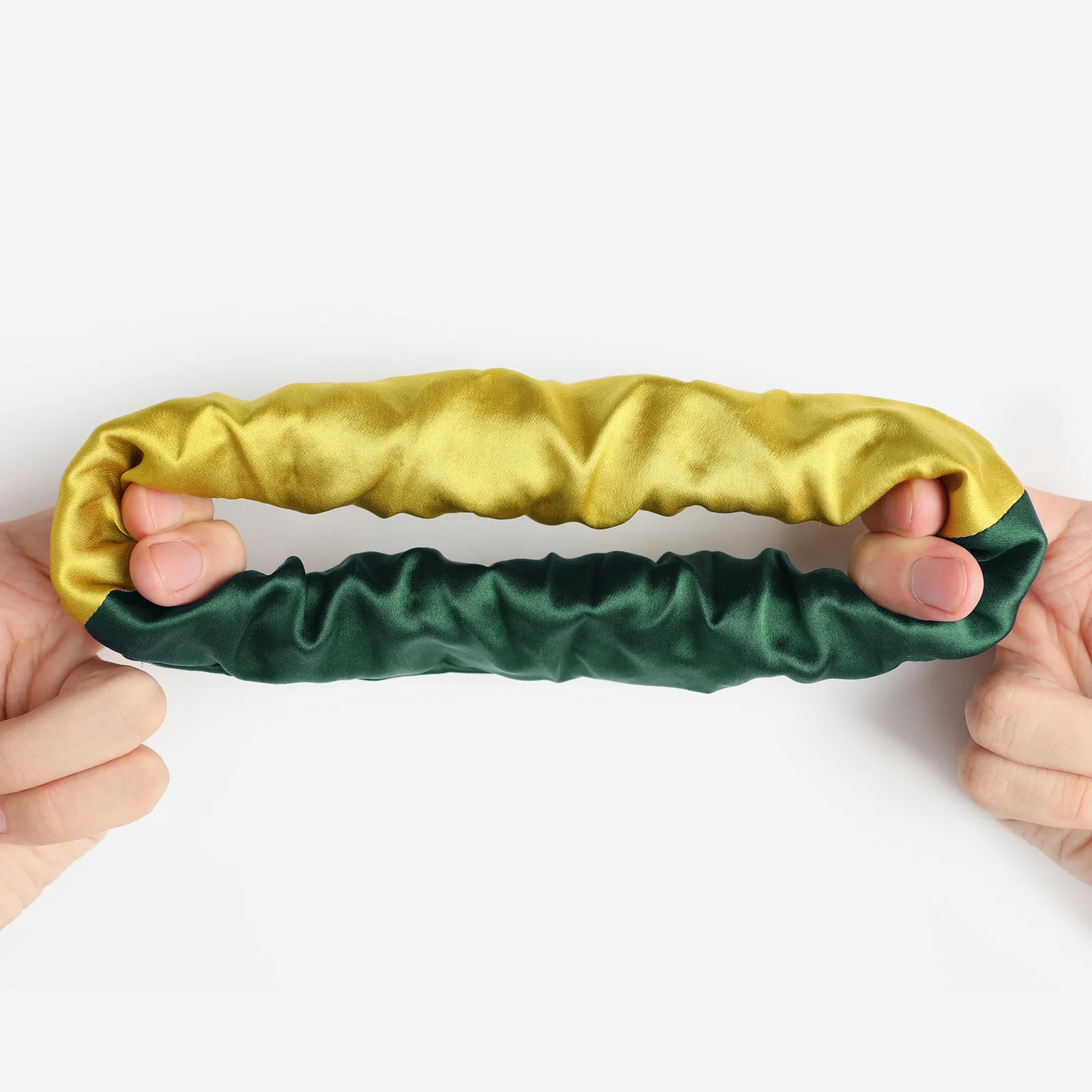 Detail view of two-tone custom silk scrunchie in green and yellow for private label hair accessory and gift set brands