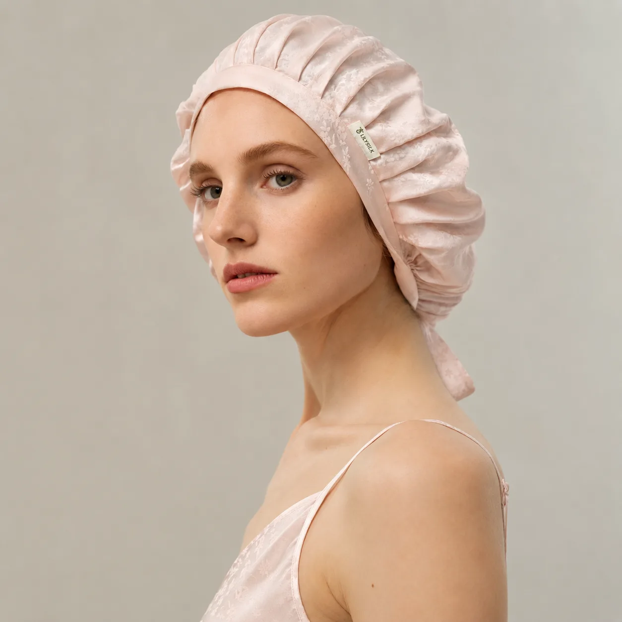Private label pink patterned silk hair bonnet with side logo label for beauty, spa, and retail gift set programs