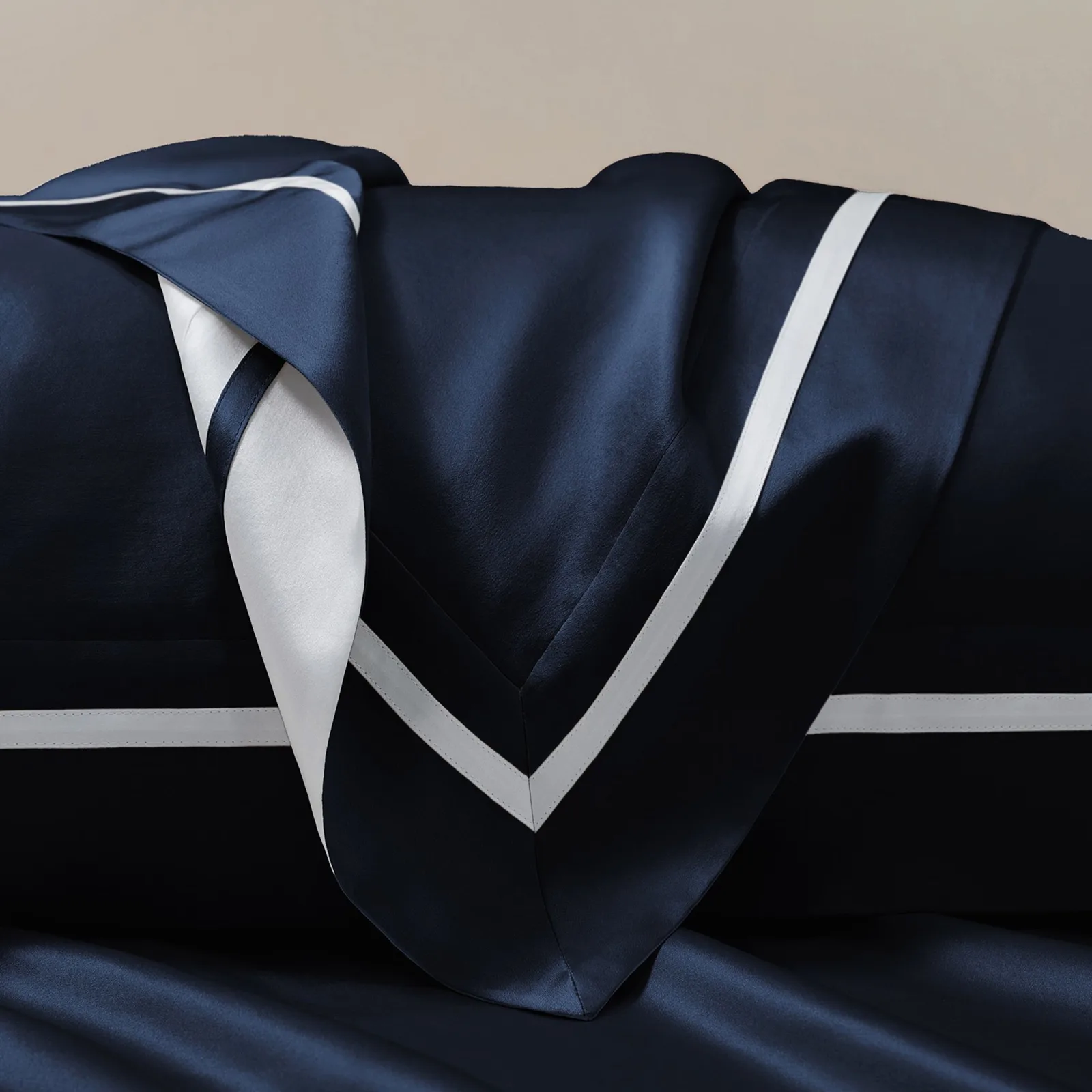 Navy custom silk pillowcase detail with white contrast piping for private label hair and sleep care lines