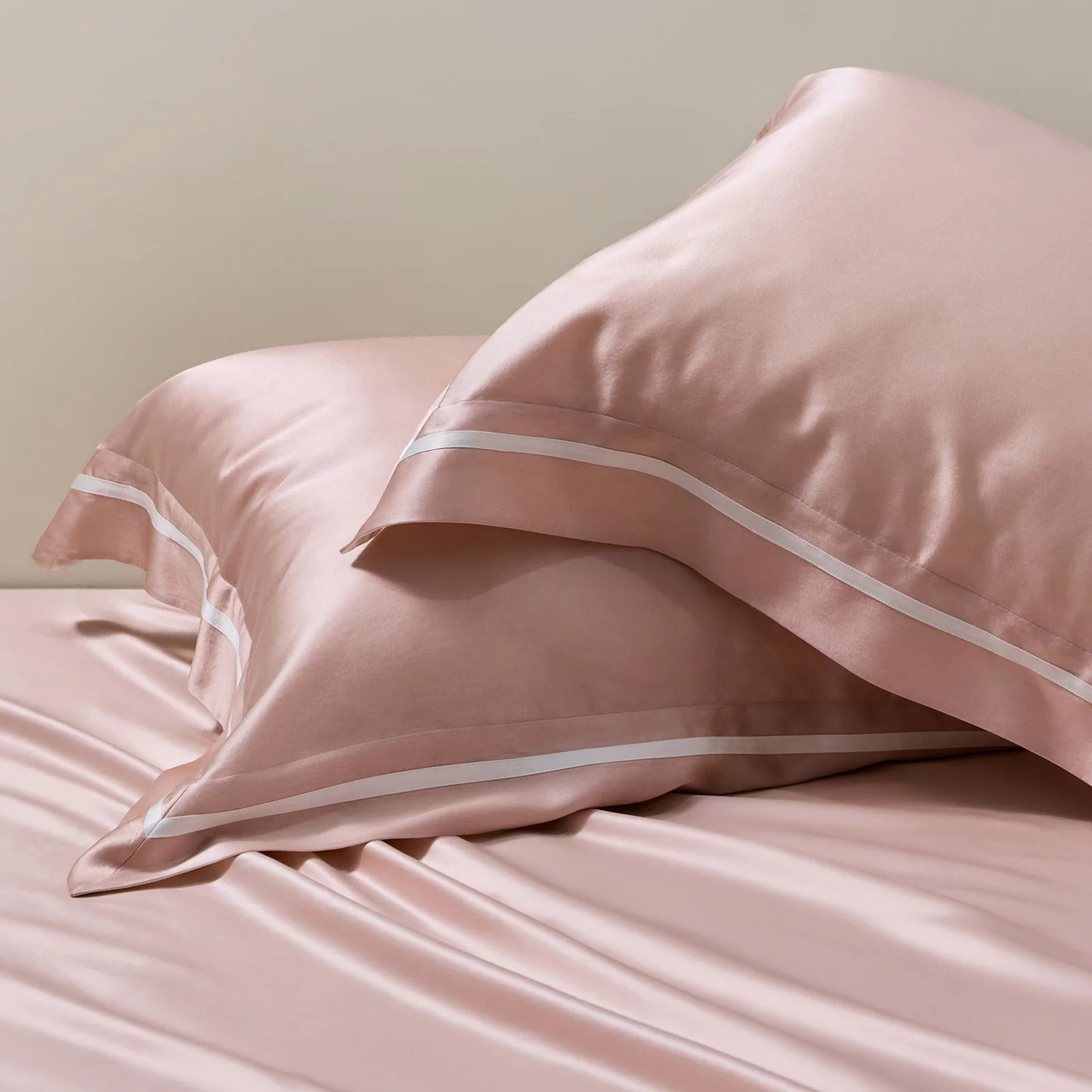 Detail view of blush pink custom silk bedding with contrast piping for private label bedding collections