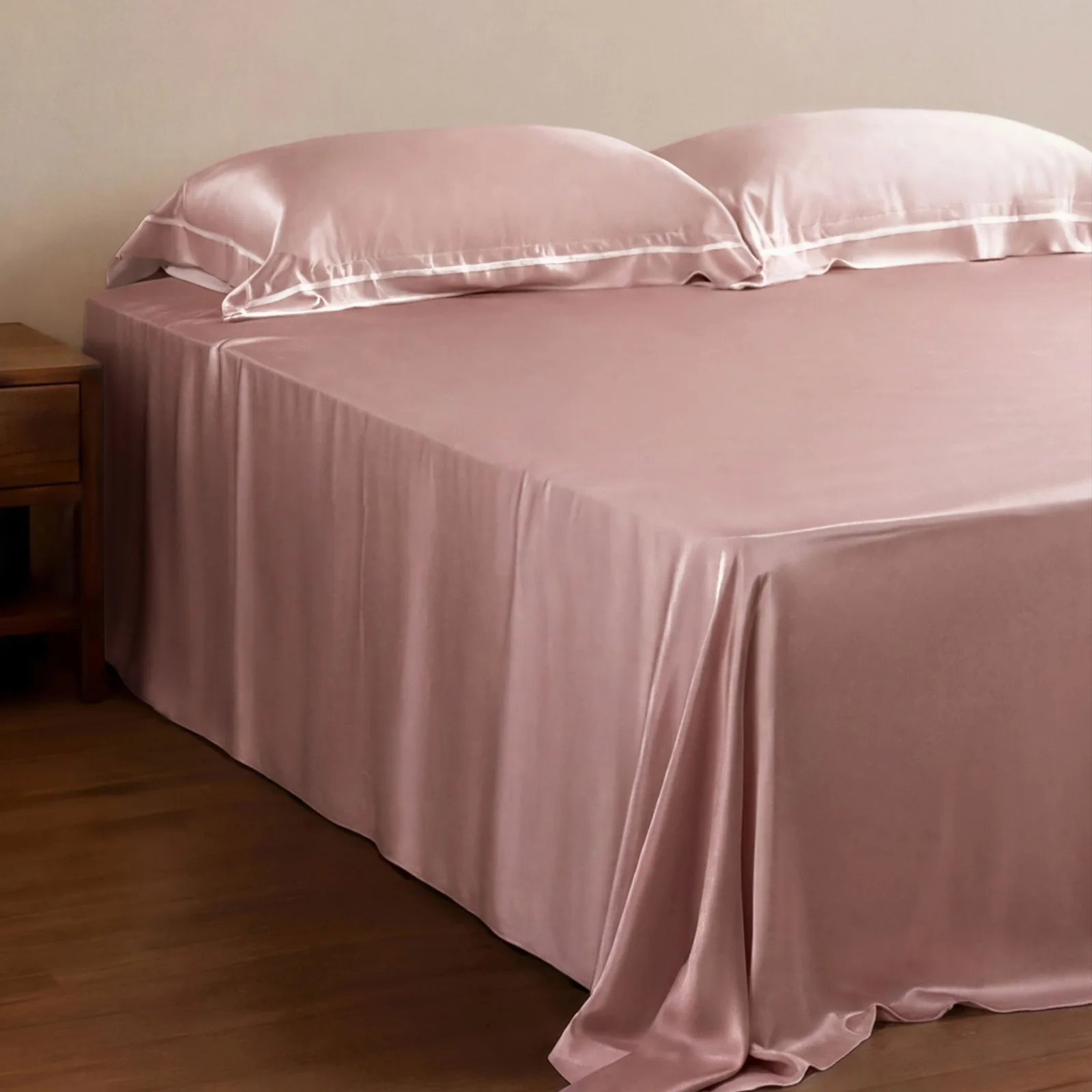 Pink custom silk bedding style with draped sheet and piped pillowcases for private label bedding programs