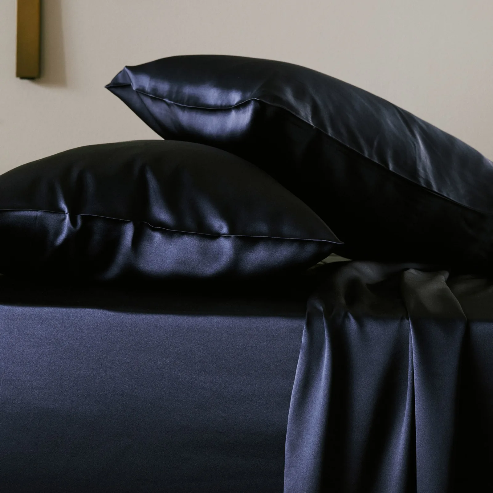 Dark navy custom silk bedding detail with smooth sheen, pillowcases and sheet styling for private label bedding collections