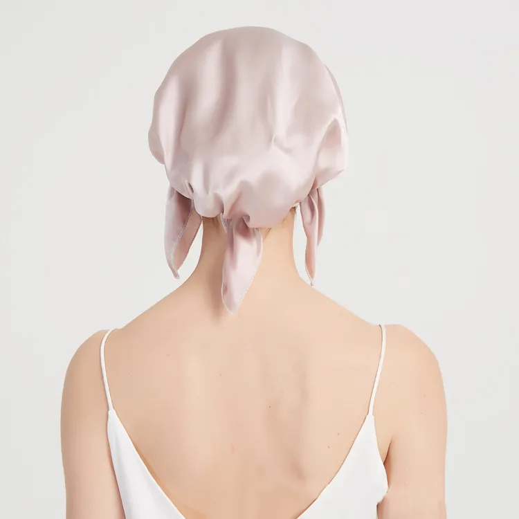 Model wearing blush tie-back custom silk sleep cap for private label hair care and beauty brand collections