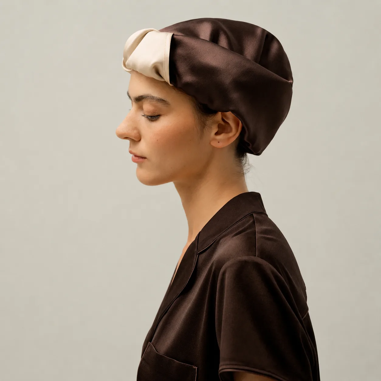 Side detail of two-tone custom silk sleep cap with wide band for private label hair care and beauty brands