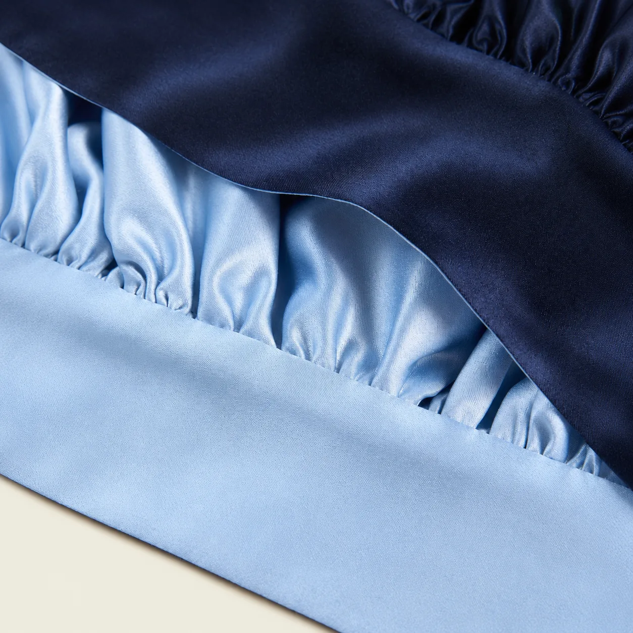Detail view of custom silk sleep cap with gathered elastic band and two-tone navy and light blue finish for private label hair care brands