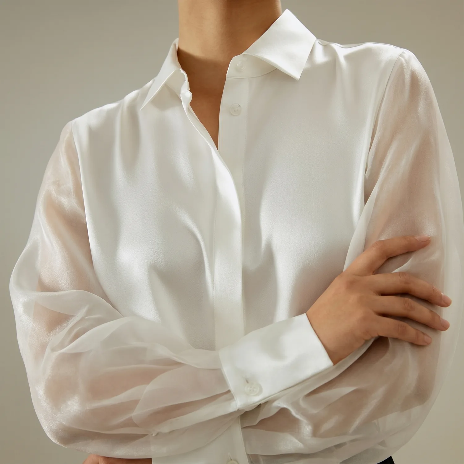 Detail view of white custom silk shirt with structured collar and sheer sleeves for private label apparel development