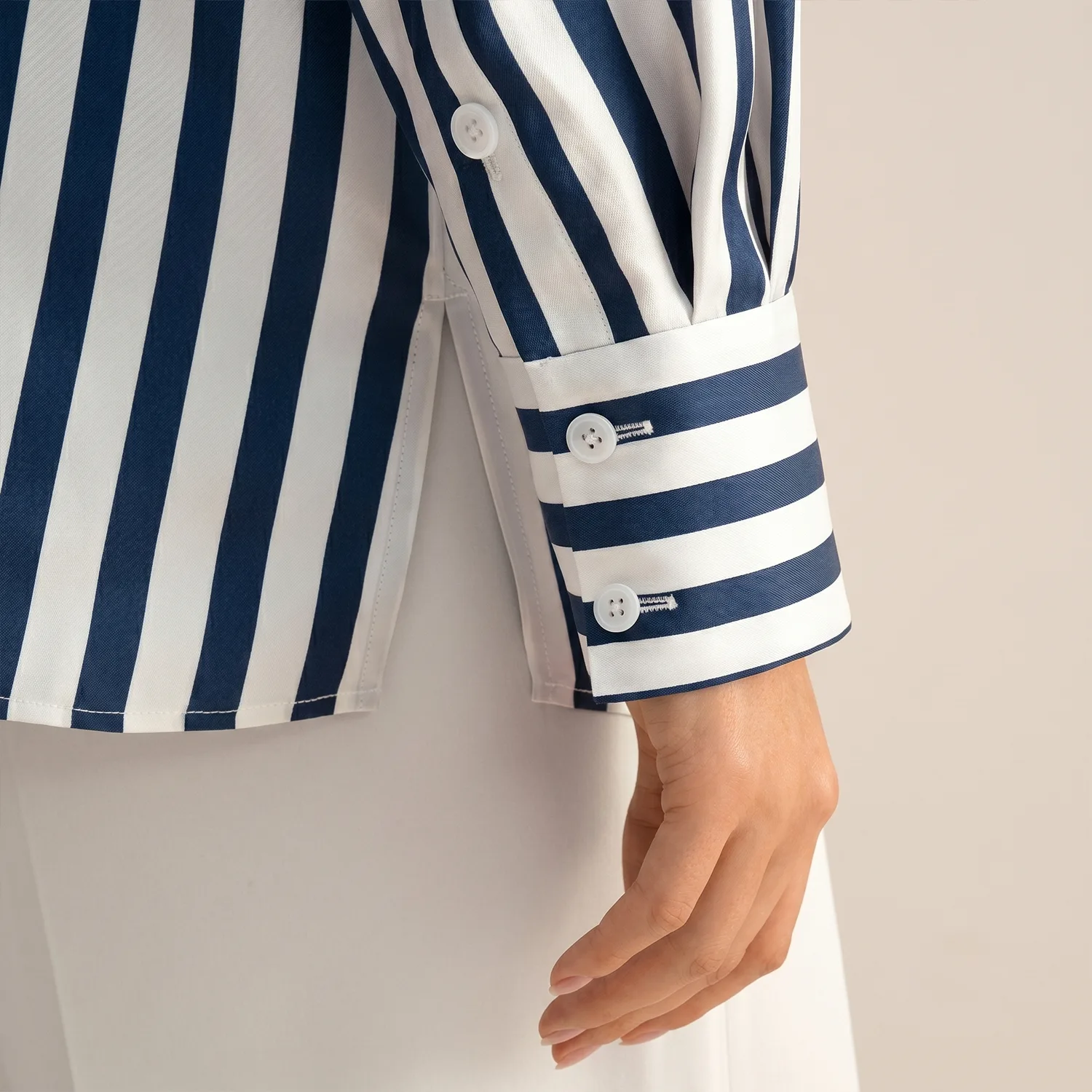 Detail view of navy and white striped button-front shirt with cuff for custom silk clothing private label apparel development