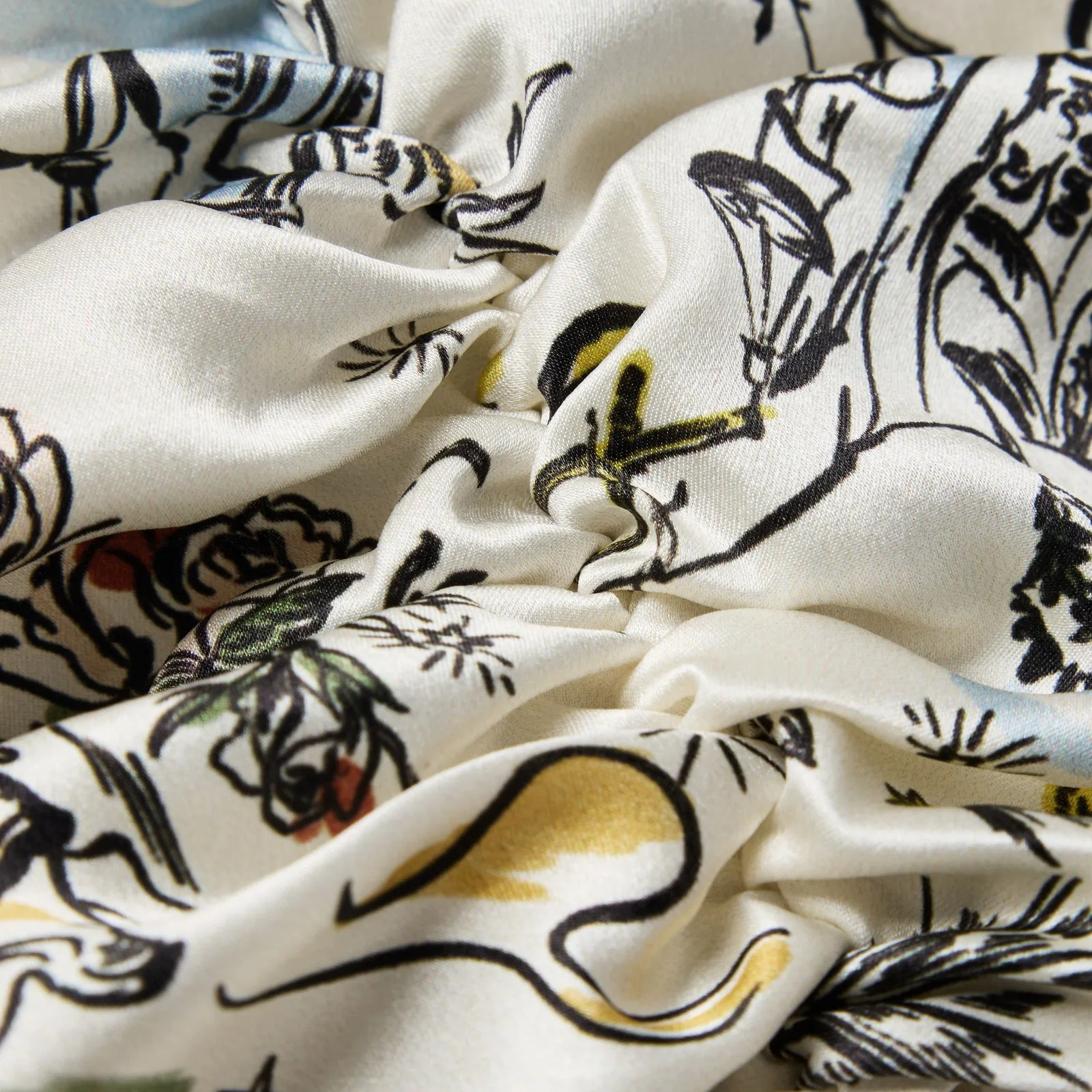Detail view of printed ivory fabric with black line artwork for custom silk sleep caps for private label hair care brands
