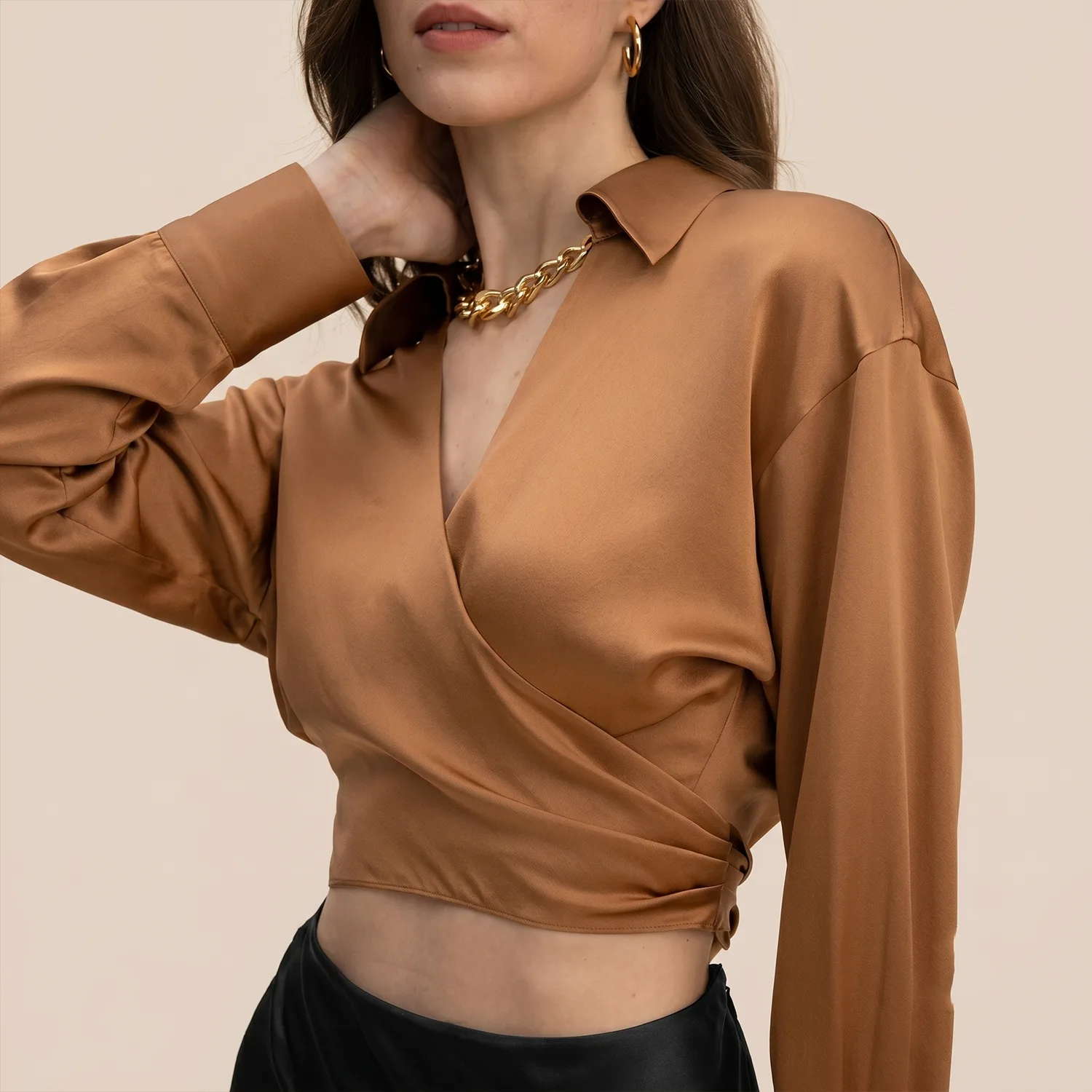 Detail view of bronze wrap-style silk blouse with pointed collar and long sleeves for private label apparel brands