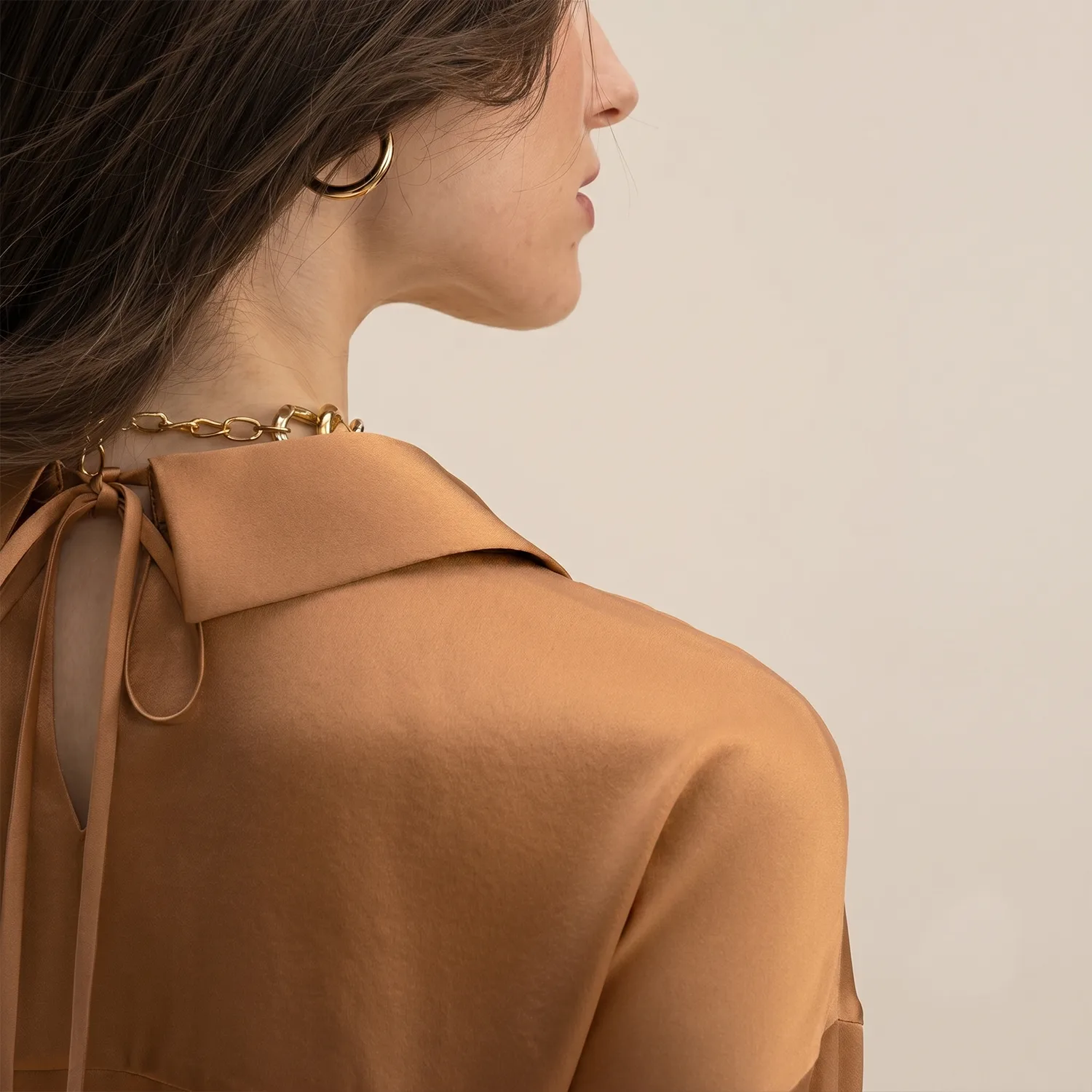 Detail view of caramel tie-neck silk shirt collar for custom private label apparel sampling
