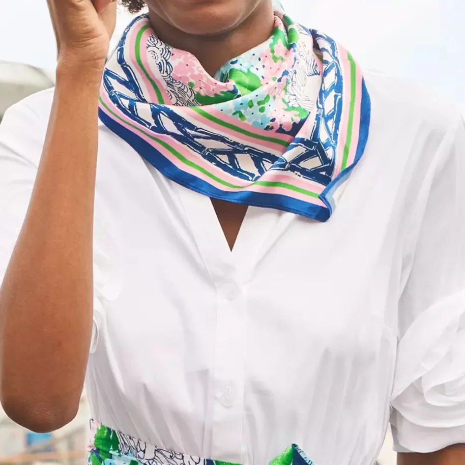 Detail view of a custom printed silk scarf worn as a neck accessory, showing border artwork and color placement for private label scarf projects