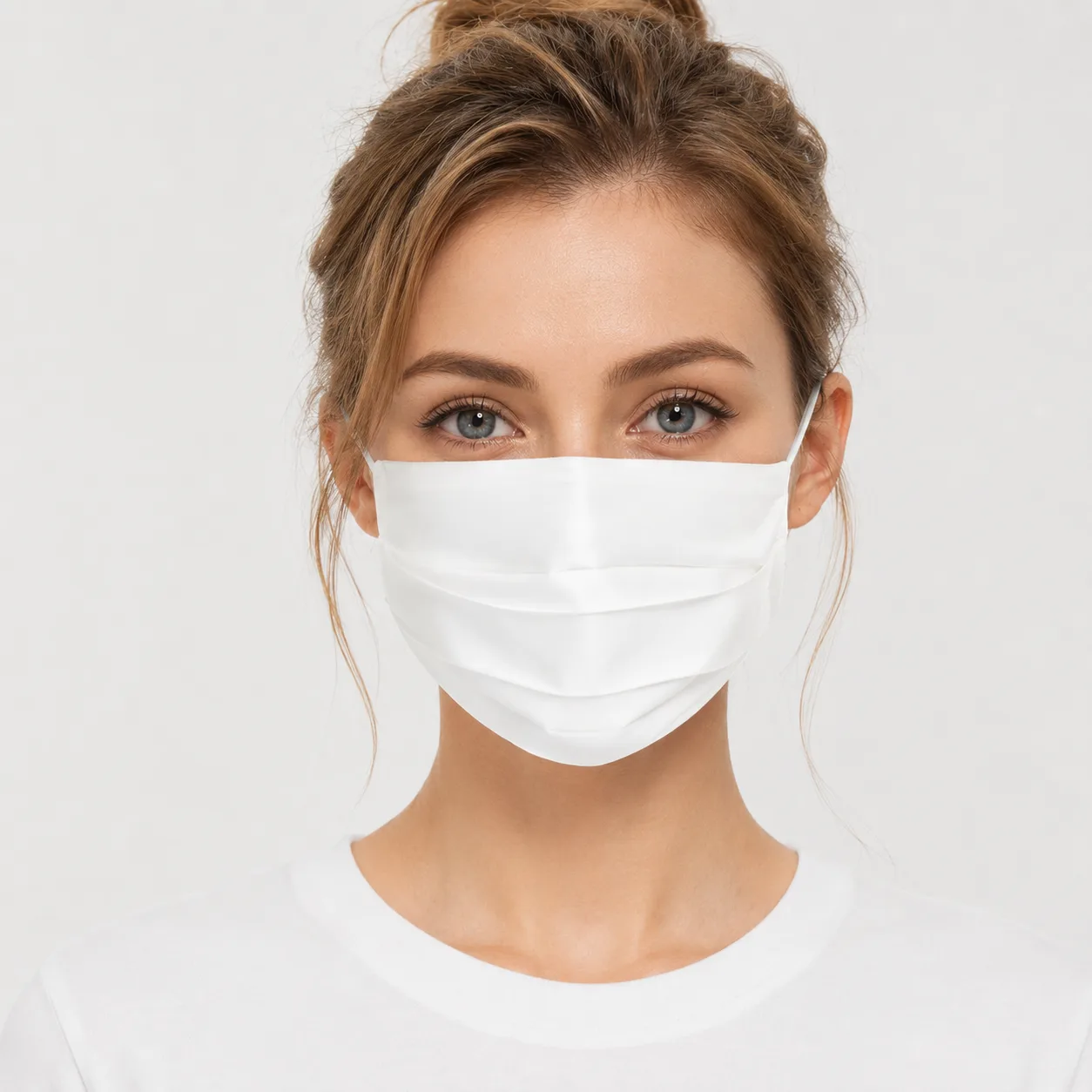 White 19 momme mulberry silk pleated face mask worn on model, shown for private label gift set and spa brand programs