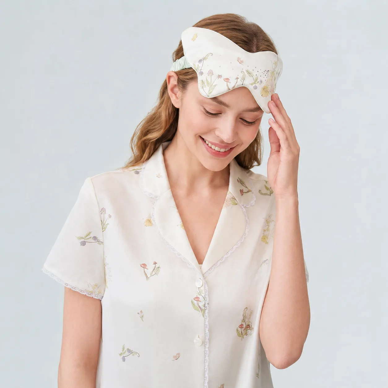 Lifestyle image of a floral custom silk sleep mask with matching sleepwear for private label beauty, travel, spa, and gift programs