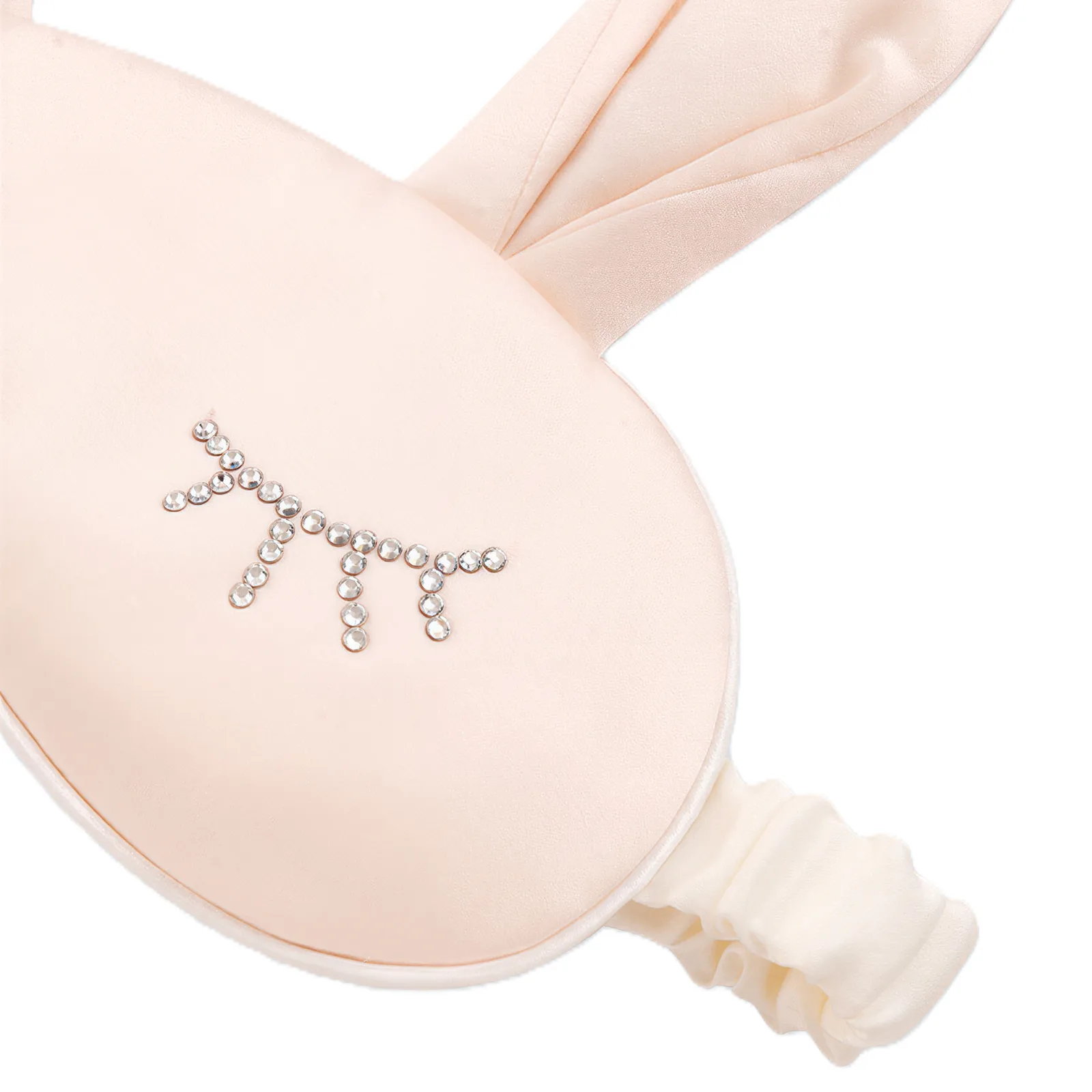 Kids silk sleep mask detail showing padded rounded eye shape, bound edge seam, soft ear extensions, and gathered elastic band for comfortable fit