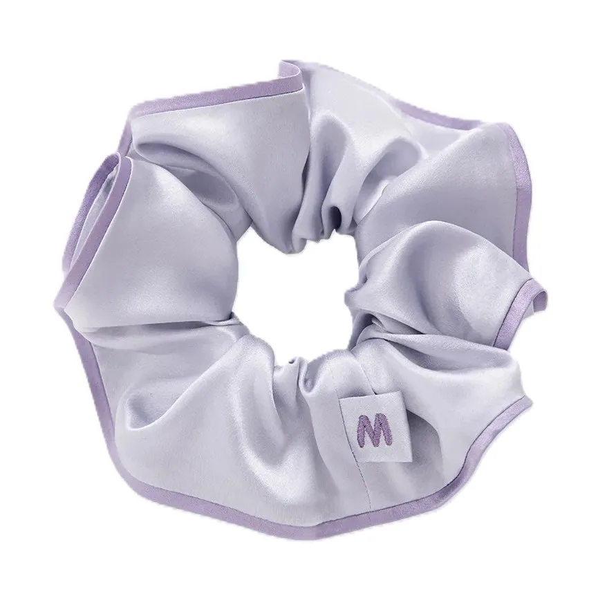 Detail view of private label silk scrunchie with gathered elastic band, soft folds, and bound edge finish for comfortable hair hold