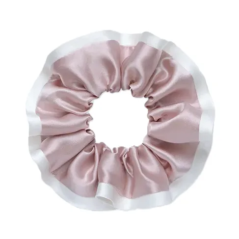 Detail view of a custom silk scrunchie with gathered circular construction, covered elastic fit, and finished border edge for private label hair