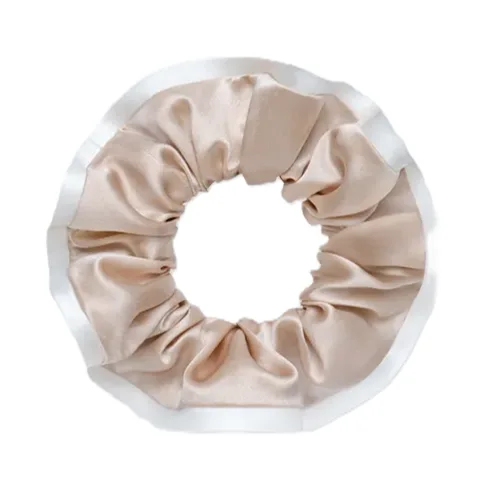 Detail view of a round gathered silk scrunchie with contrast border edge and enclosed elastic band for private label hair accessory projects