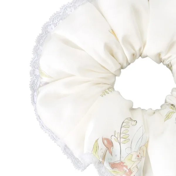 Detail view of a custom silk scrunchie with gathered fabric, elasticated ring structure, and lace-trim edge for comfortable hair accessory fit