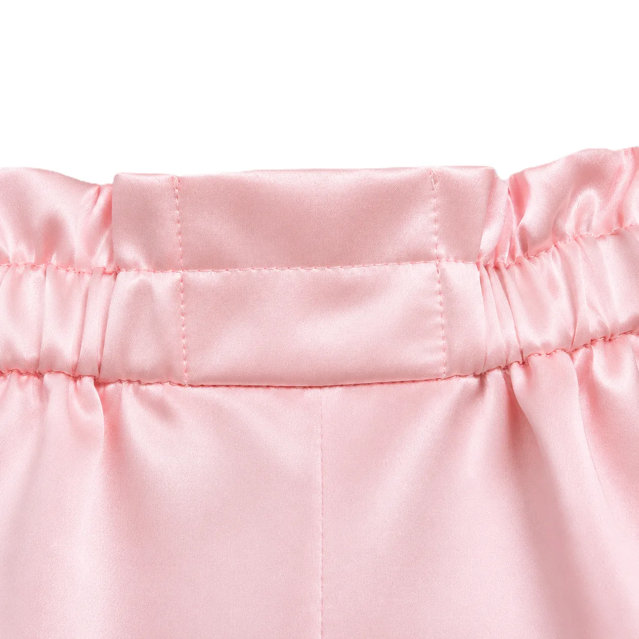 Detail view of custom kids silk product construction with elastic waistband, stitched panel, and gathered seams for flexible comfort
