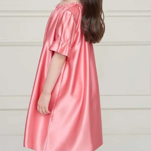 Detail view of a custom kids nightgown with loose A-line construction, gathered elastic neckline, short sleeves with ruffled cuffs, and relaxed