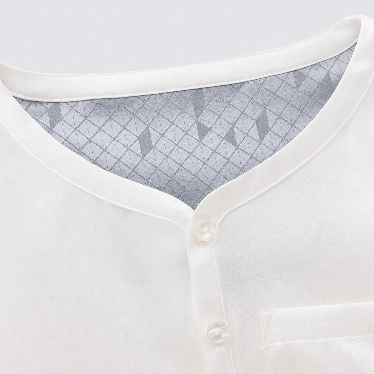 Detail of kids private label top with rounded neckline, bound edge seams, button placket, and smooth inner facing for comfortable fit