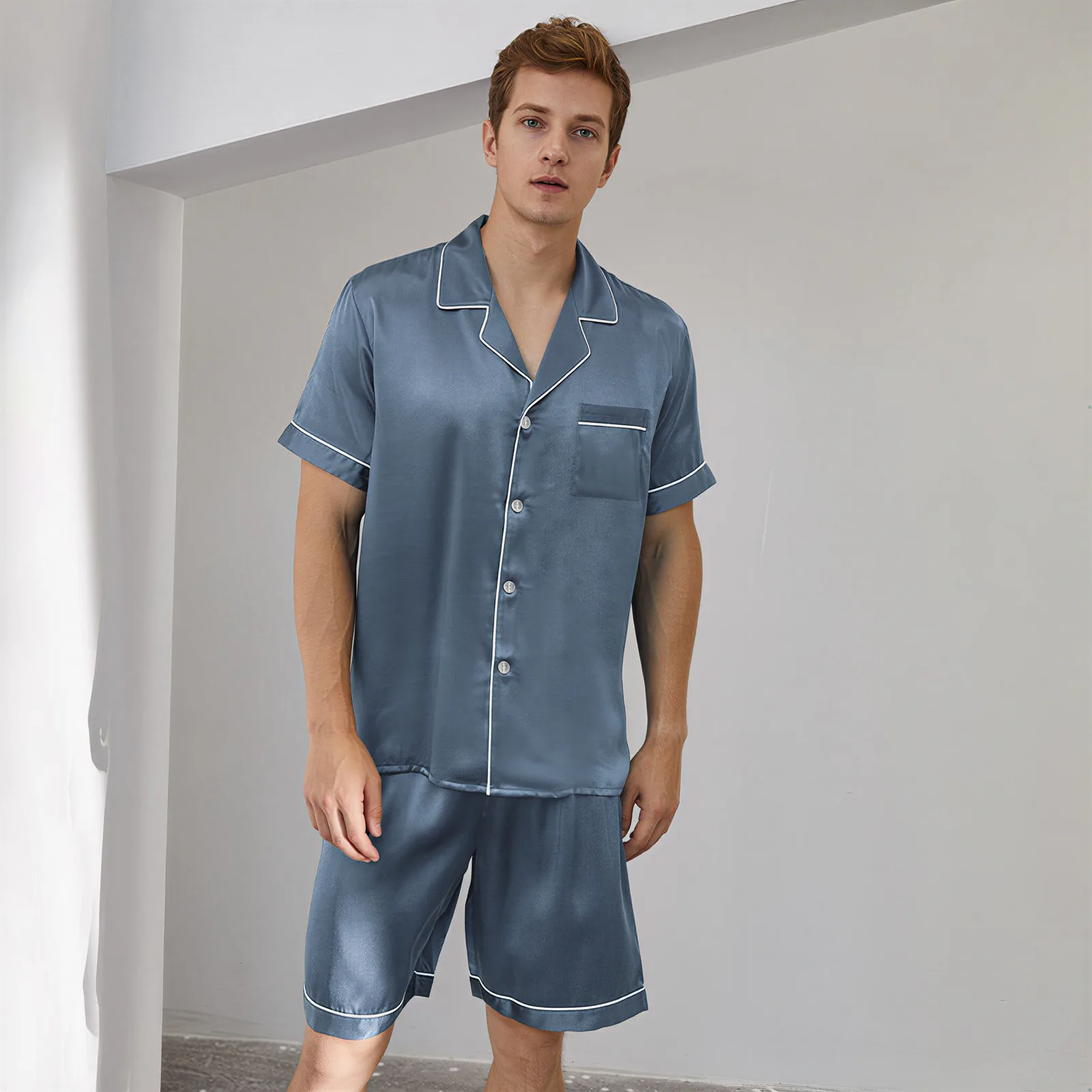 Detail view of custom silk pajama short set with notched collar, button front, piped edges, chest pocket, and relaxed-fit shorts for private label