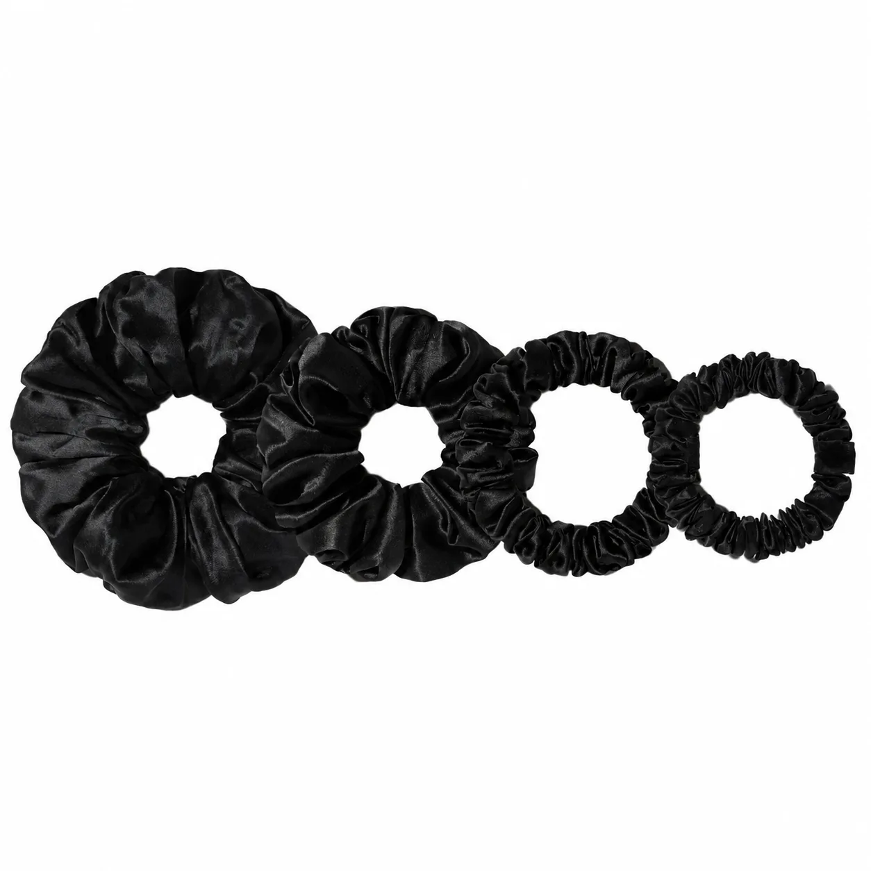 Detail view of custom silk scrunchies featuring varied sizes and gathered construction for optimized comfort and aesthetic appeal, designed for