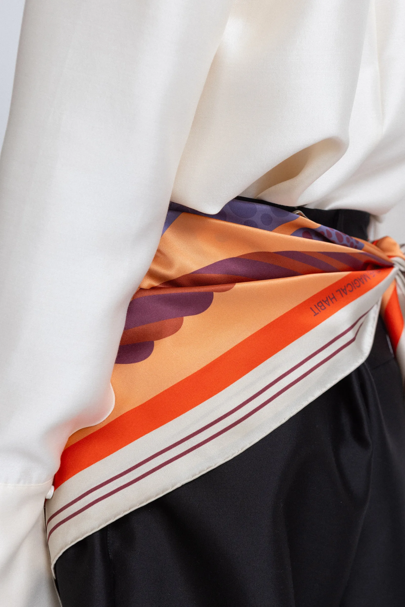 Detail view showcasing the construction of a custom vintage paisley print silk square scarf, featuring a well-finished edge and comfortable knotting