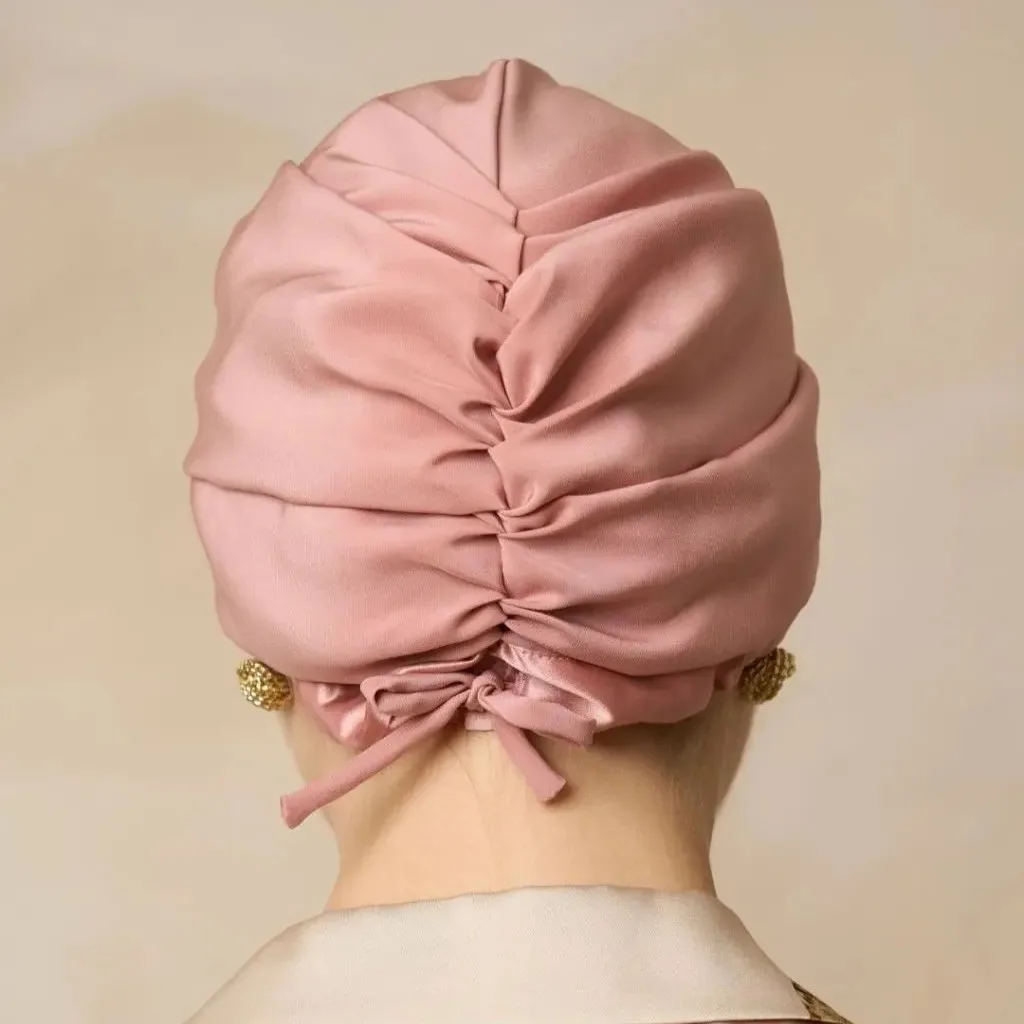 Detail view of a custom silk sleep cap featuring a gathered design and back tie for secure fit, ideal for hair care and beauty brands