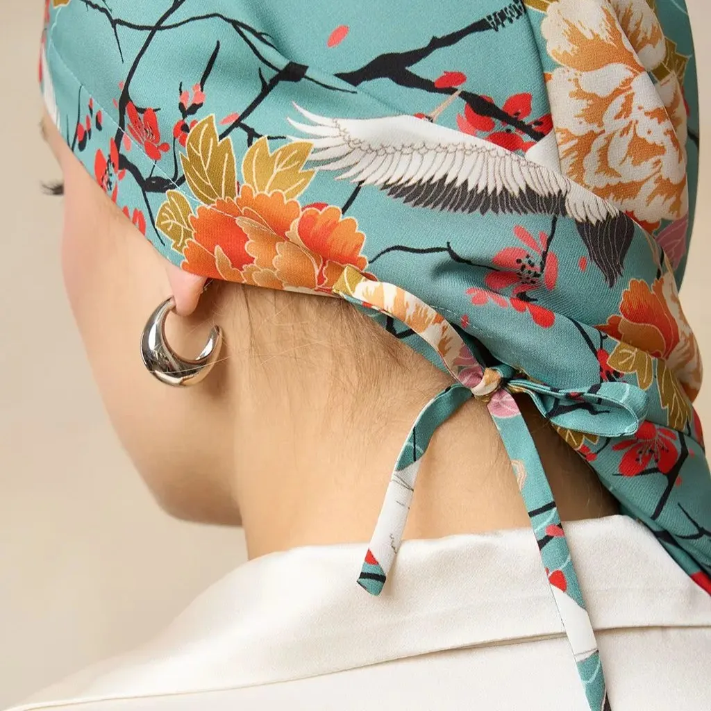 Detail view of a custom silk sleep cap showcasing its tied-back design, featuring a floral print and a comfortable fit for hair care and beauty brands