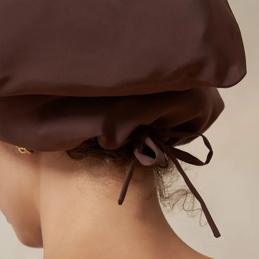 Detail view of a custom silk sleep cap featuring a gathered construction with adjustable tie closure, designed for comfort and secure fit for hair