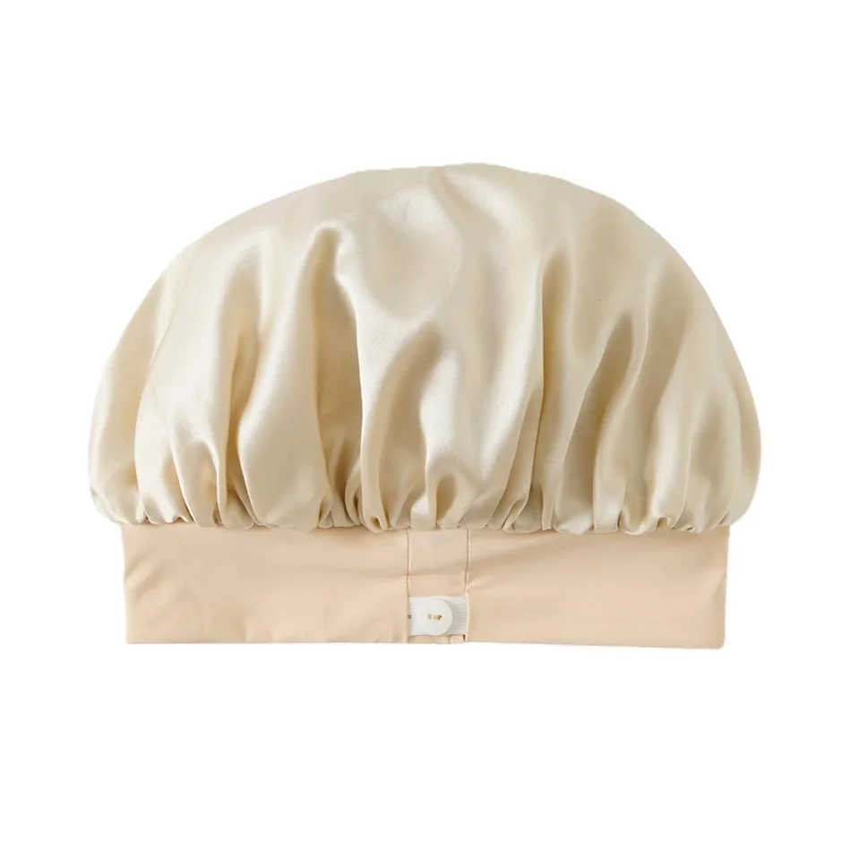 Detail view of a custom silk sleep cap featuring a spacious, gathered crown for comfort and a secure fit with a button closure, designed for beauty