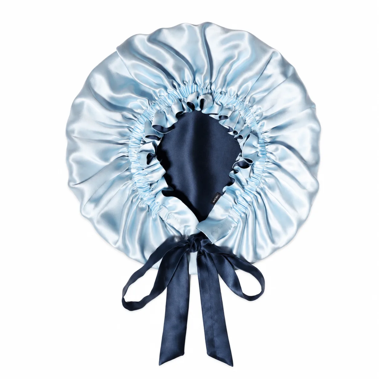 Detail view of a custom silk sleep cap featuring a gathered elastic edge and satin ties, designed for optimal comfort and fit for hair care and beauty