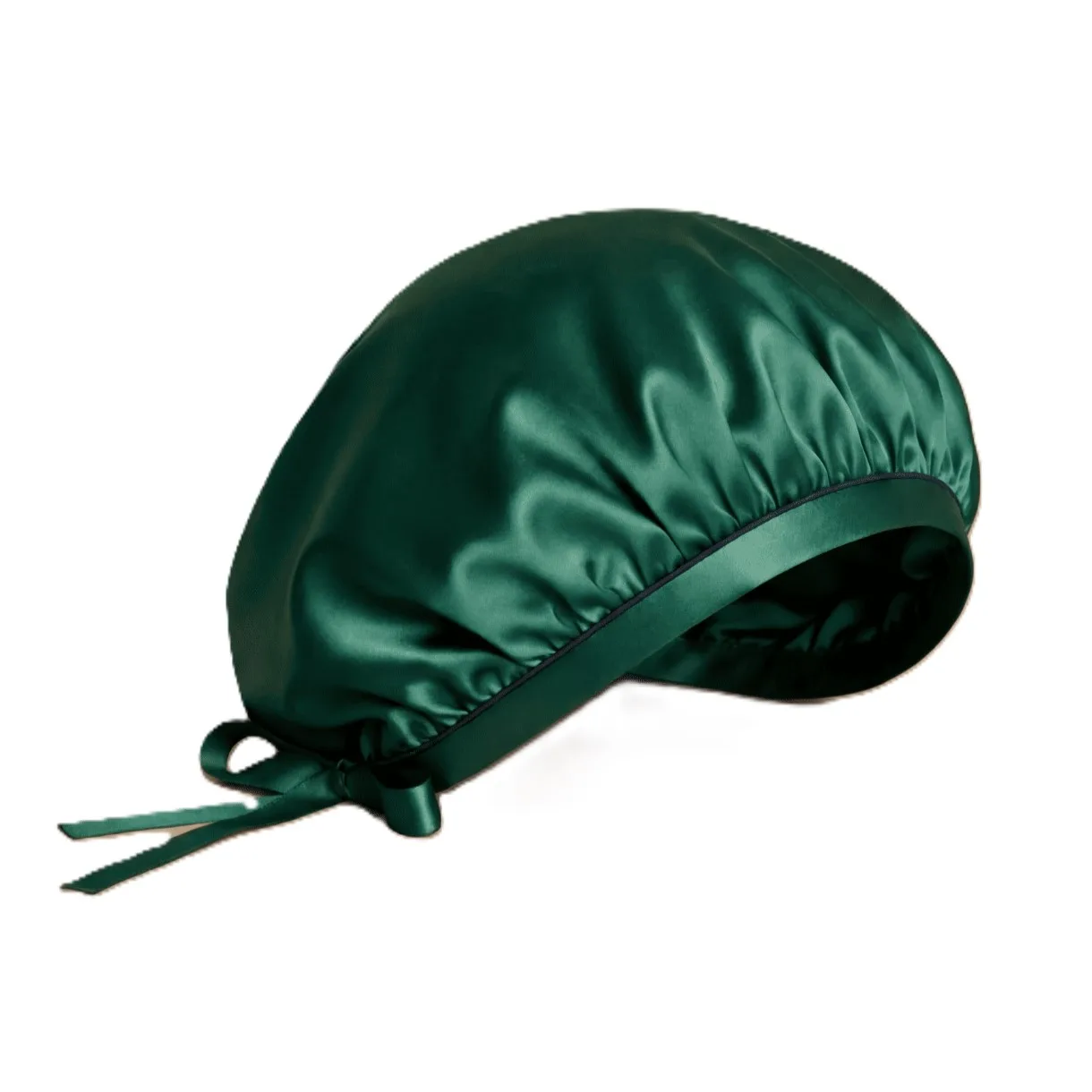 Detail view of a custom silk sleep cap showcasing its rounded construction, gathered edge finish, and adjustable ribbon ties for a secure fit, ideal