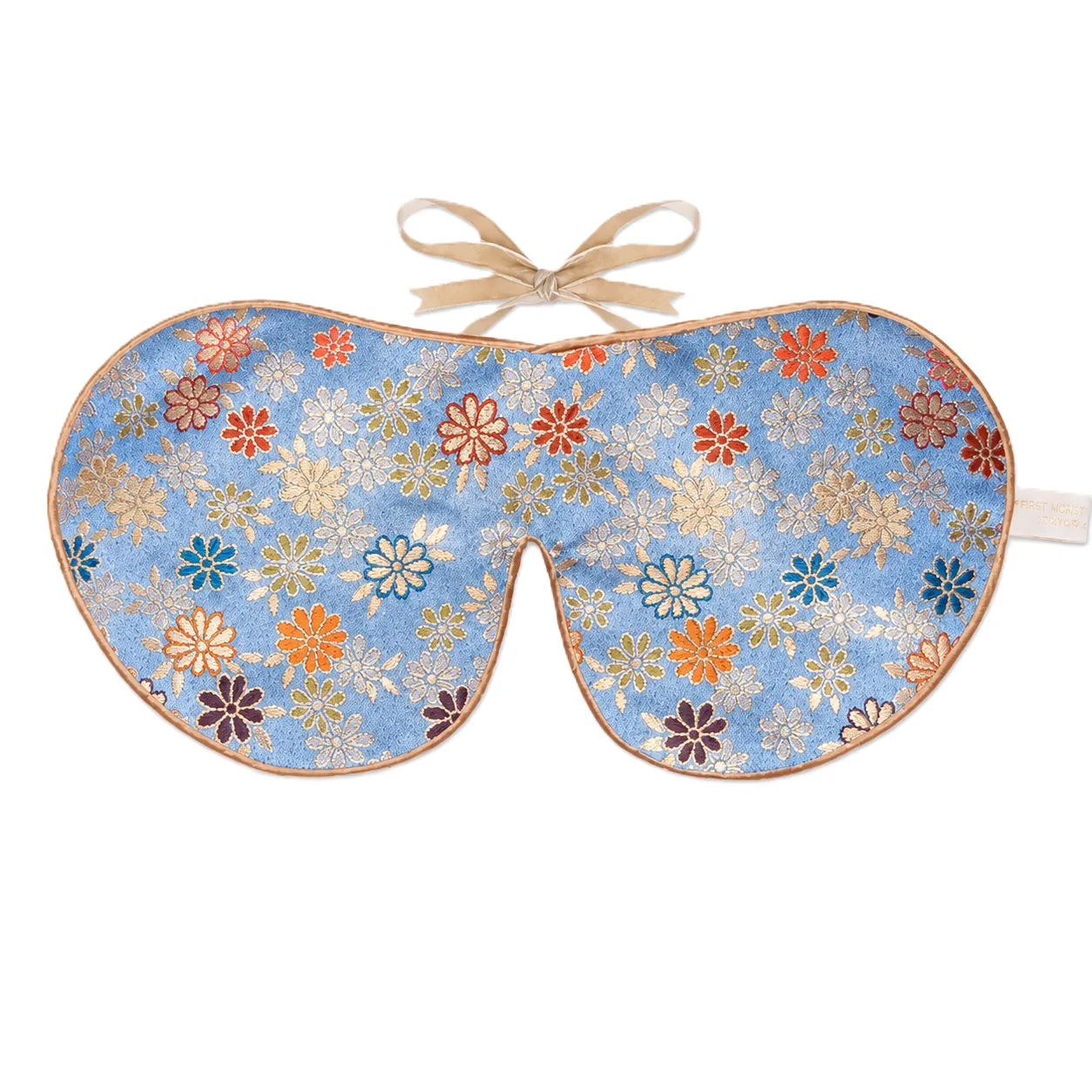 Detail view of a custom silk sleep mask featuring an elegant floral design, designed for optimal comfort with soft edges, adjustable tie closure for a