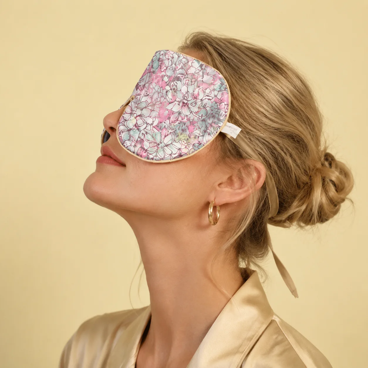 Detail view of a custom silk sleep mask featuring a floral design, showcasing its ergonomic shape and soft edge finish for optimal comfort