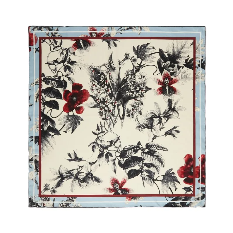Detail view of a custom silk scarf featuring intricate floral patterns and color-blocked edges, designed for private label fashion brands