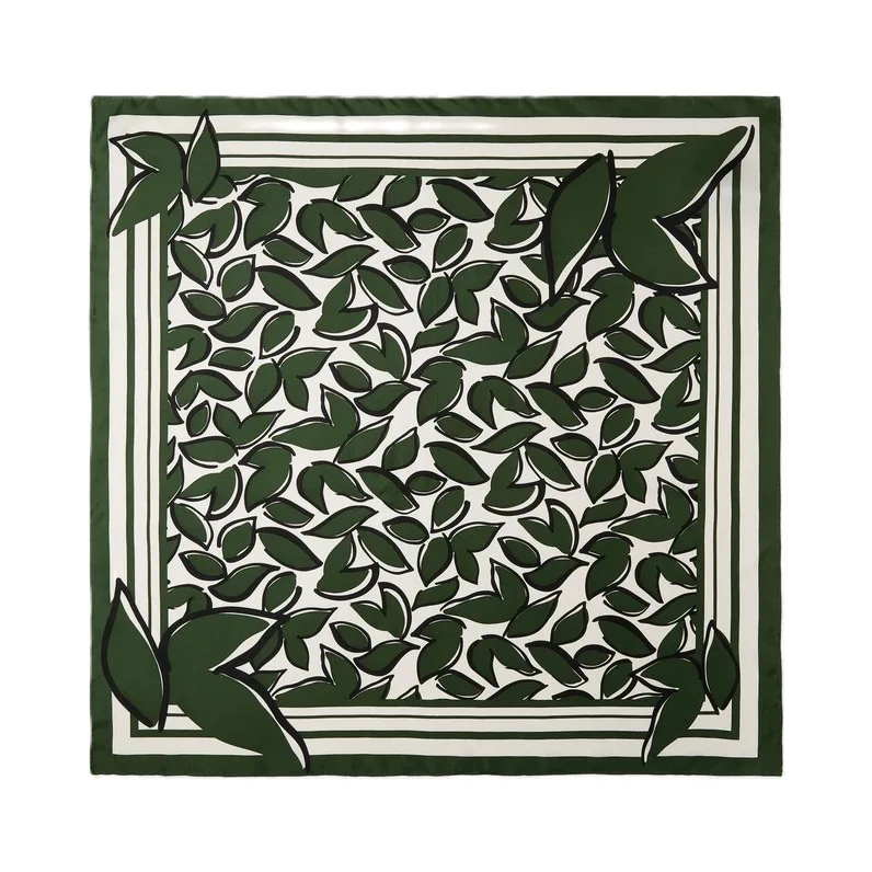 Detail view of custom silk scarf featuring an elegant leaf pattern, highlighting the precise edge finish and structured design for private label