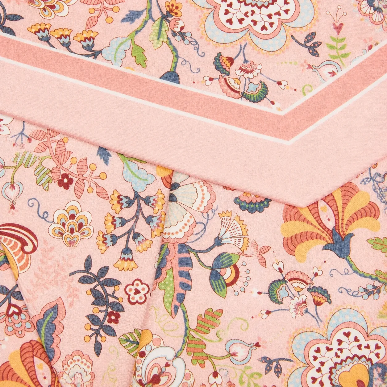 Detail view showcasing the elegant construction and edge finish of a custom silk scarf designed for private label brands, featuring clean seams and a